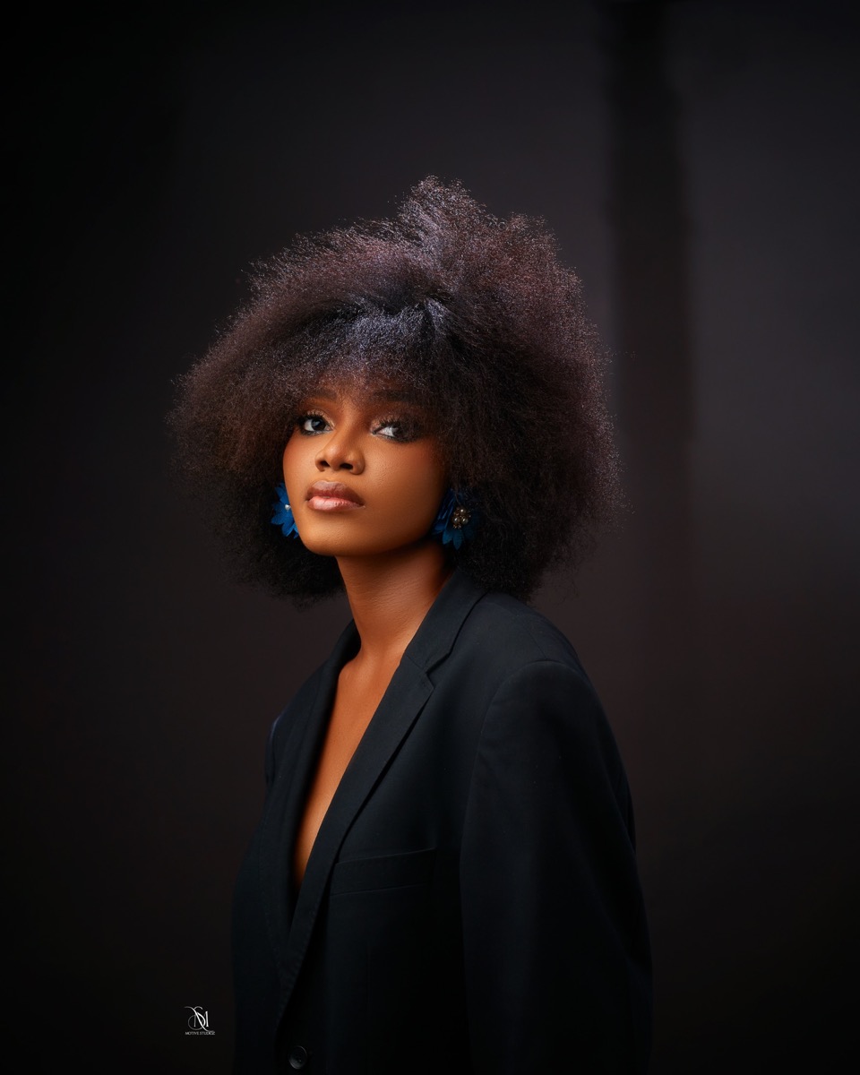 Studio portrait with afro hair against a dark backdrop