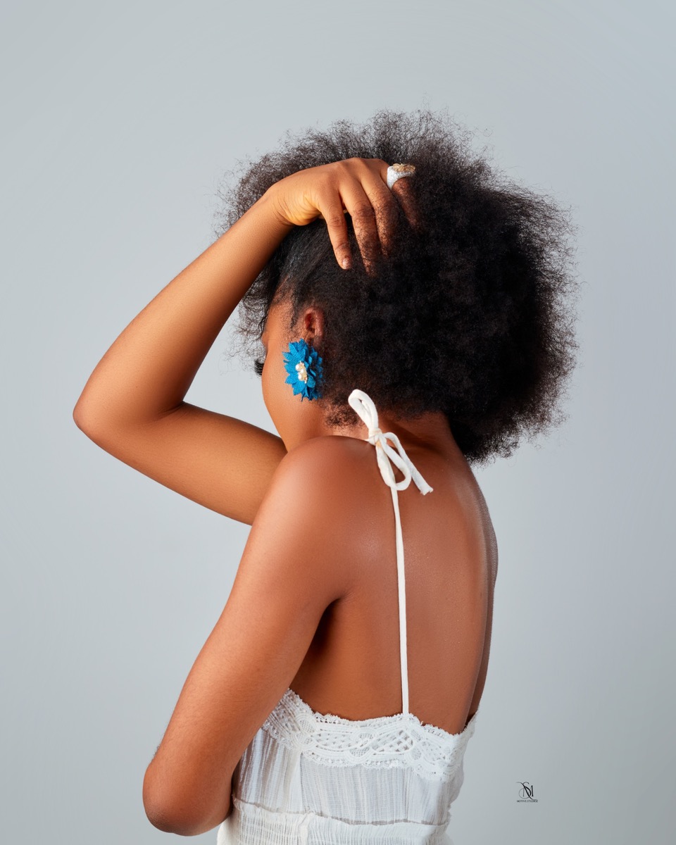 Close portrait showing natural hair and a white dress